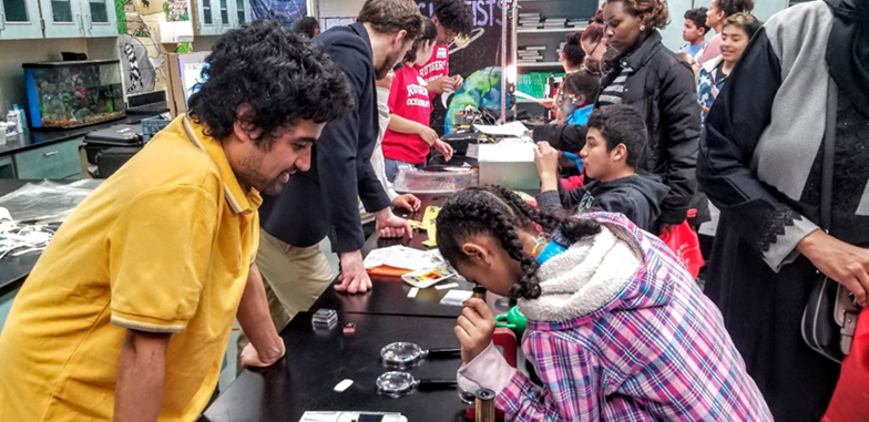 Dr. Saroj Poudel exploring our microscopic world with students who constructed their own paper foldscopes.